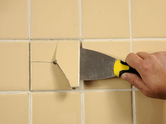 Lift out the loose tile with a putty knife.