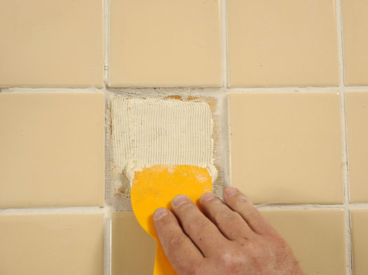 Apply adhesive to the new tile and to the floor.