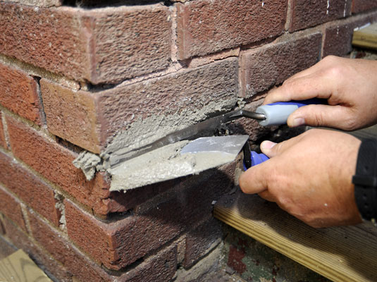 Push the mortar in between the brick.