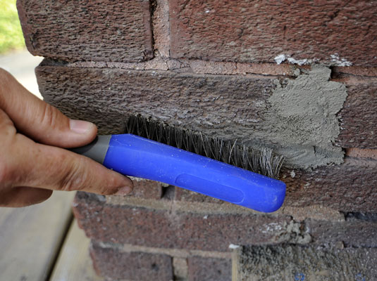 Scrub the area with a stiff brush to wipe away particles of mortar on the bricks.