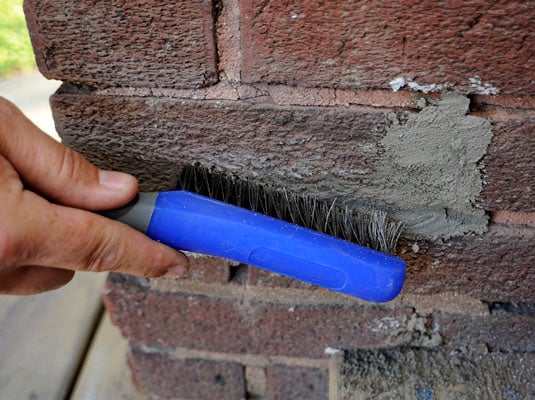 Scrub the area with a stiff brush to wipe away particles of mortar on the bricks.