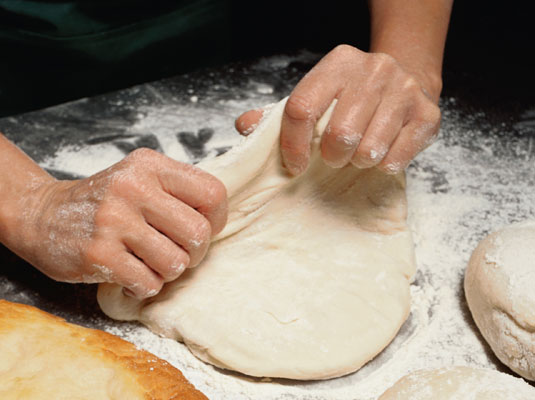Place a ball of dough on a floured counter or work surface, and flatten it with your hands.