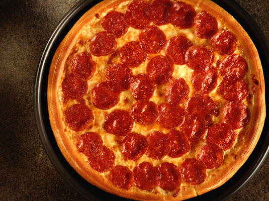 Bake the pizza in a 450-degree oven until the cheese turns golden brown in spots and the edge of the crust looks golden brown.