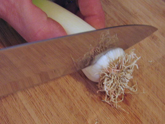 Cut off the roots of the leek.