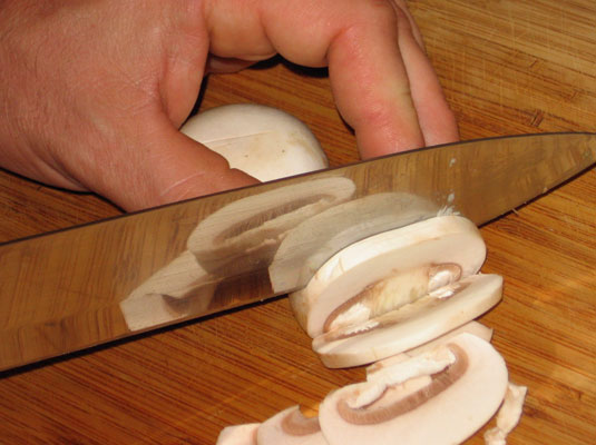 Place the mushroom caps, flat-side down, and slice them perpendicular to the cutting board.