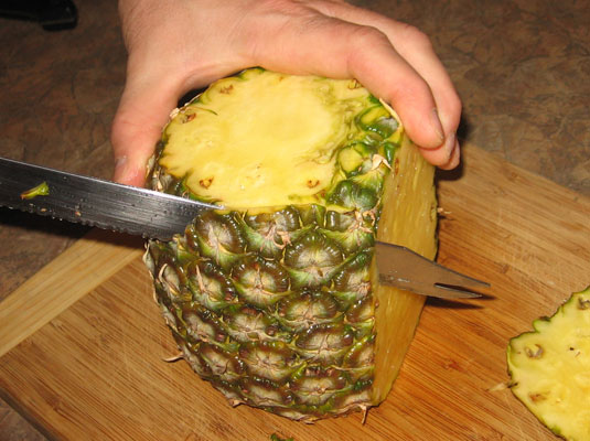 Set the pineapple upright and cut off the eyes.