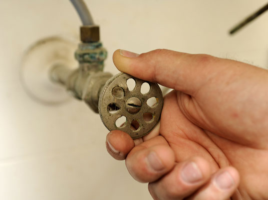 Turn off the water at the valve under the sink, and turn on the faucet at the sink until the water stops running.