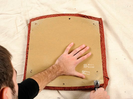 <b>Staple the board </b>into<b> place to hide the cut edges of the fabric.</b>