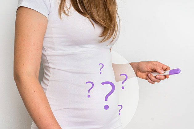 Woman holding a pregnancy test wondering if she is pregnant