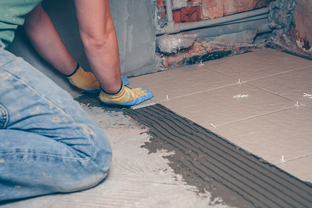 man installing tiles on the floor