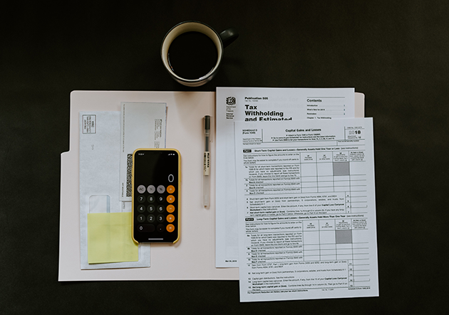 Open file folder with tax worksheets and a calculator inside