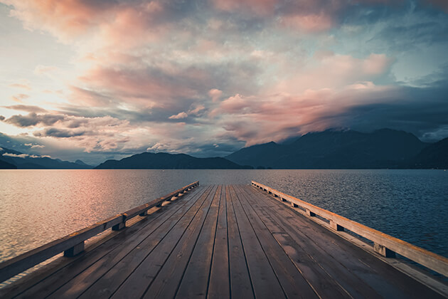 pier on a lake with hills in the background