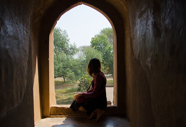 Sitting woman framed by arched window