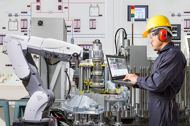 Photo of man working with a robotic arm on vehicle parts