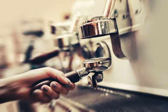 A barista inserts the tamper tool.