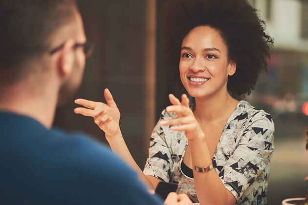 Phot of a woman smiling and talking to a man