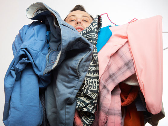 man under a pile of clothing