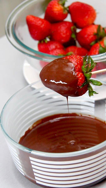 Dip the strawberries, one at a time, in the melted chocolate.