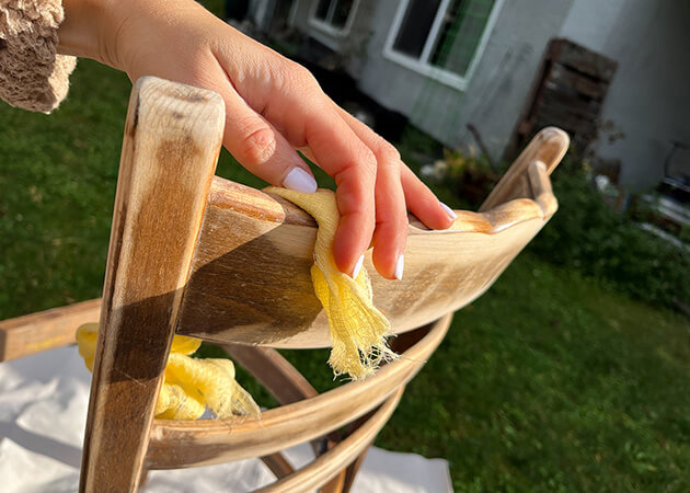 Photo showing the use of tack cloth to remove dust from a chair after sanding