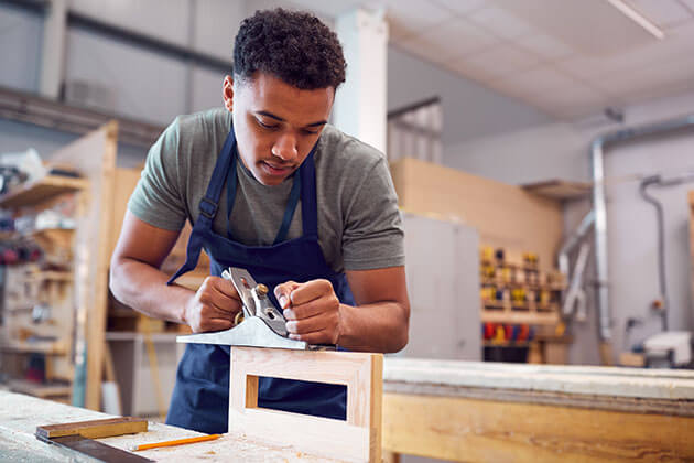 Young man working in wood shop