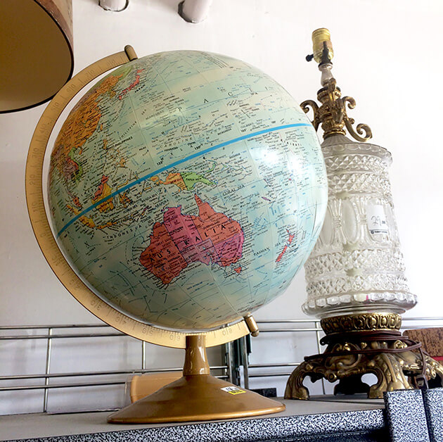 Photo of old globe and lamp on a thrift store shelf