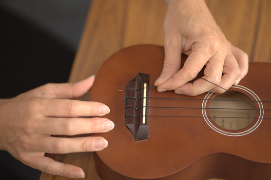 Attaching a string to a tie-on bridge, Step 1.