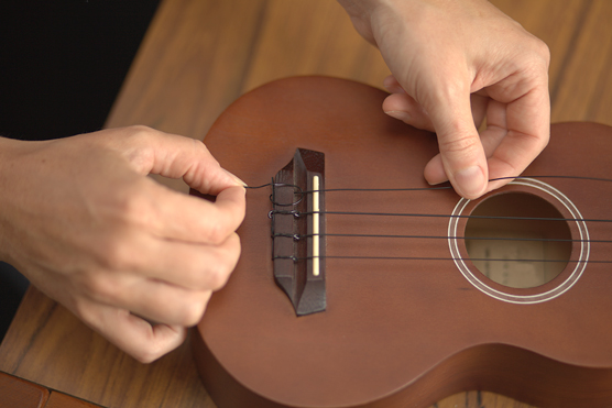 Attaching a string to a tie-on bridge, Step 2.