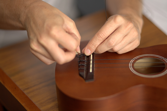 Attaching a string to a tie-on bridge, Step 3.